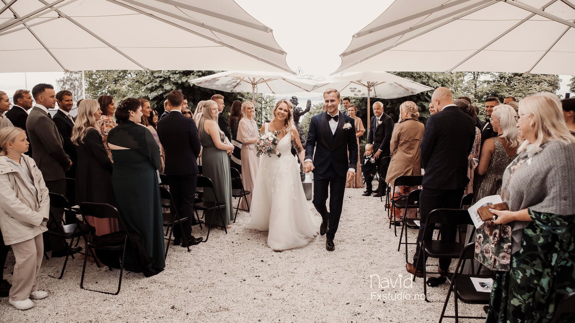 Vielse i hagen på Refsnes Gods med gjester samlet under trærne.