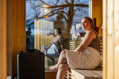 Gjest ved vinduet på Refsnes Gods badstue i hagen - atmosfære ved Oslofjorden.