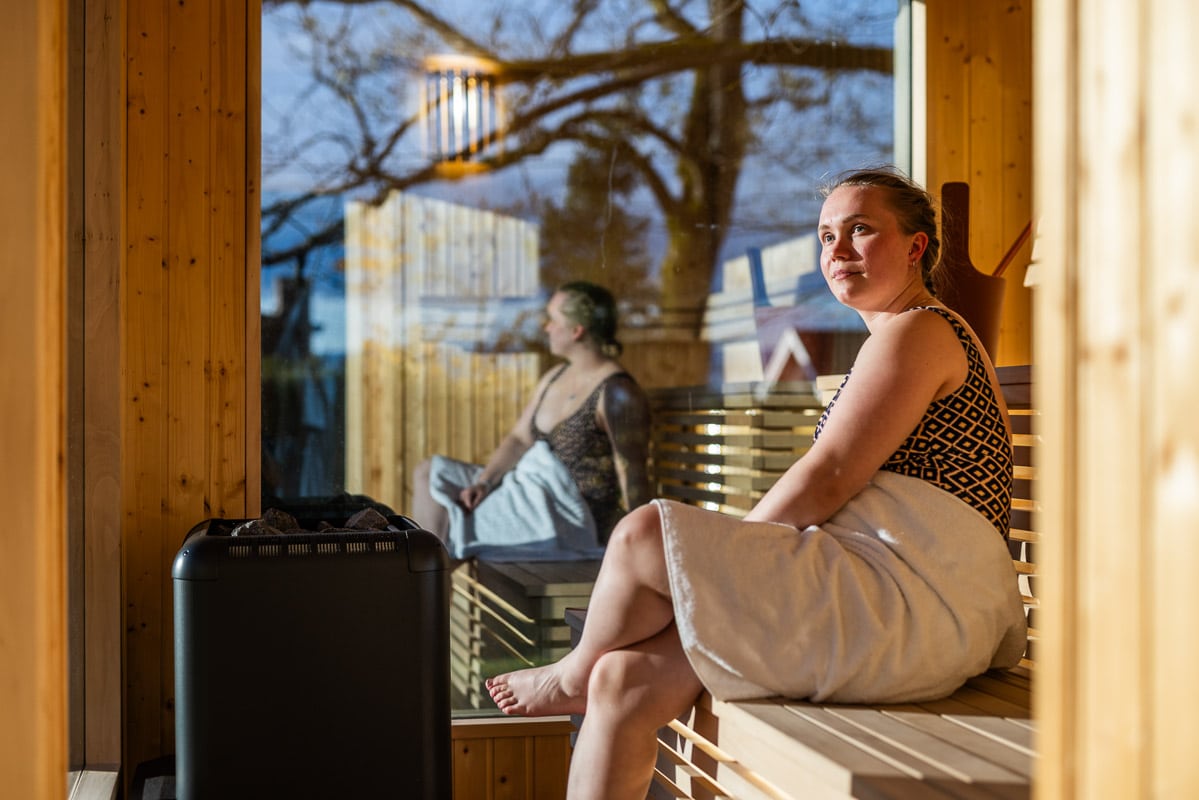 Gjest ved vinduet på Refsnes Gods badstue i hagen - atmosfære ved Oslofjorden.