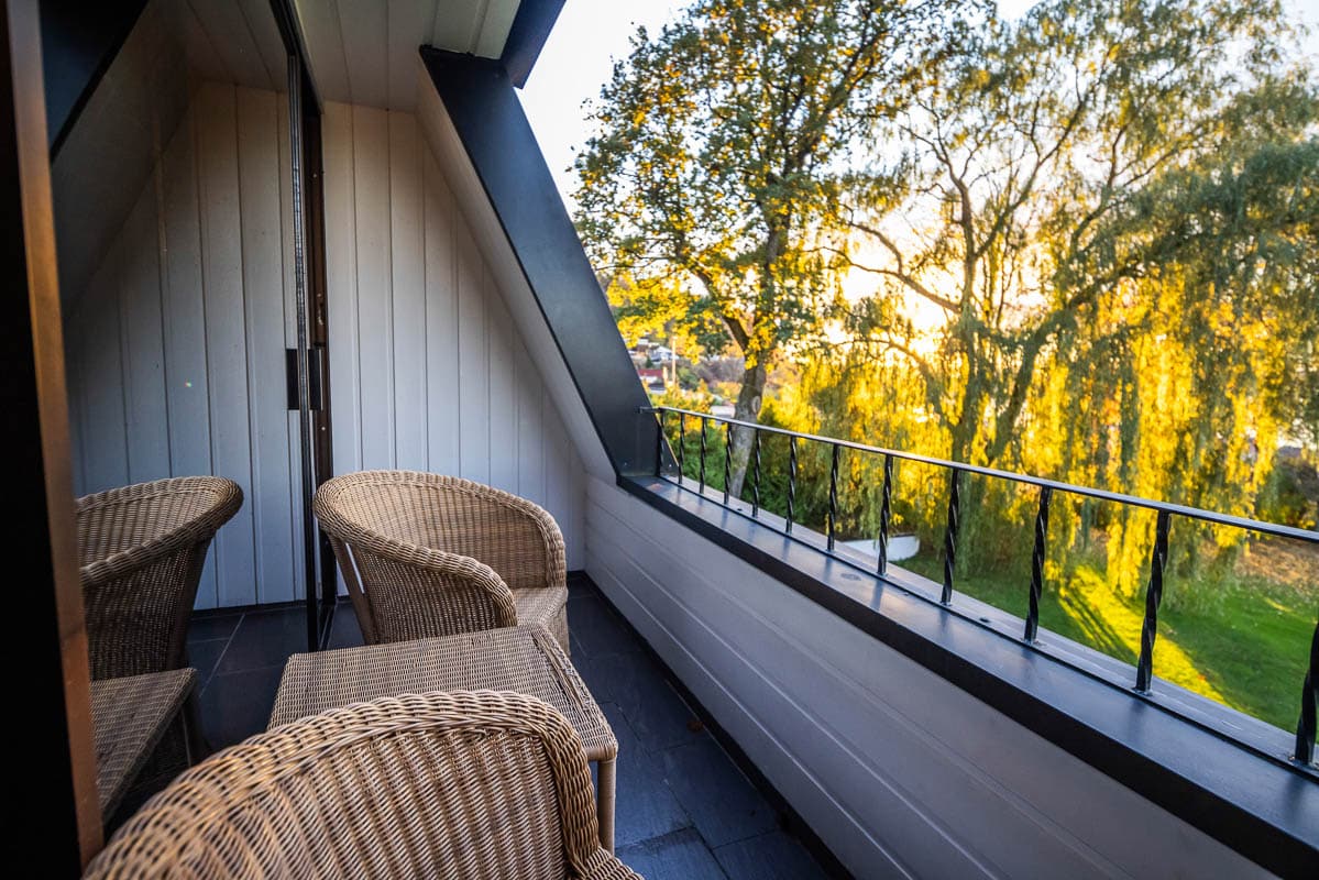 Romutsikt på Refsnes Gods kunsthotell ved Oslofjorden, omgitt av vakre trær i høstfarger.