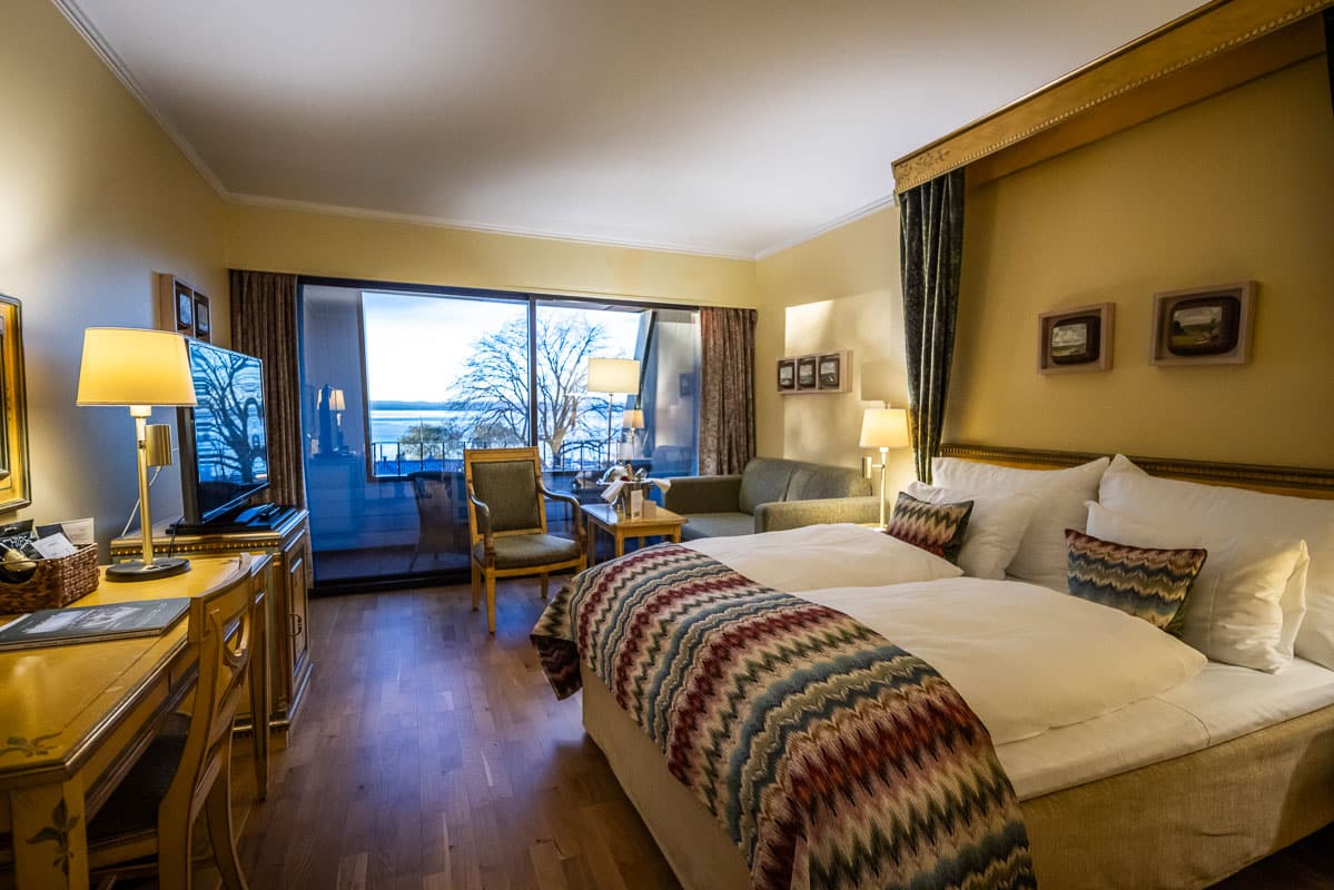 Hotellrom på Refsnes Gods hotell i Moss med store vinduer og utsikt mot hagen ved Oslofjorden.