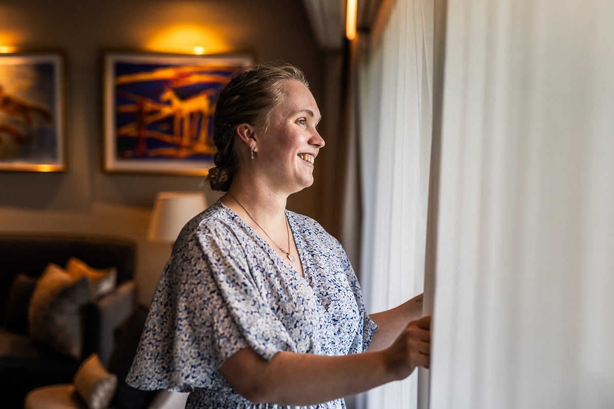 Gjest ser ut over hagen og Oslofjorden fra rom på Refsnes Gods hotell i Moss.